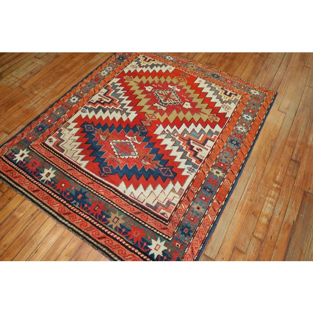An early 20th century geometric Karabagh rug with coral blue, green accents on an ivory ground, circa 1920. Measures: 4'3"...
