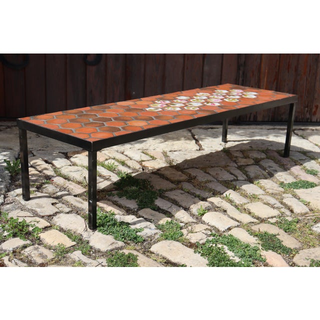Coffee table made of ceramic and Provençal terracotta tiles. Colorful floral ceramic decoration. Black metal base and...