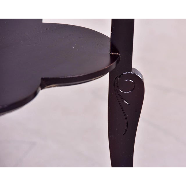 Circa 1930s French side table of black painted oak has a four leaf clover or quatrefoil shaped top and lower shelf and...