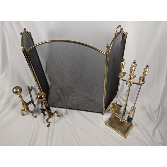 An elegant vintage brass fireplace ensemble offering a beautifully coordinated hearth presentation. The grouping includes...