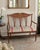 Beautiful antique Edwardian-style settee featuring a wood frame with intricate wood and mother-of-pearl inlay, elegant...