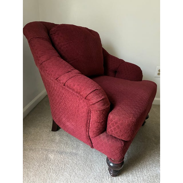 Very comfortable chair and ottoman pair in wine red fabric with subtle diagonal pattern. Wooden feet with decorative base....