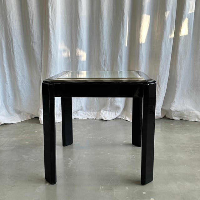 Beautiful black lacquered wood coffee table with mirror top from the 1980s. Late mid century design which recalls...