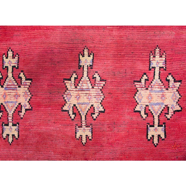 A stunning early 20th century Moroccan Berber runner with a large central diamond medallion amidst a rich crimson field of...