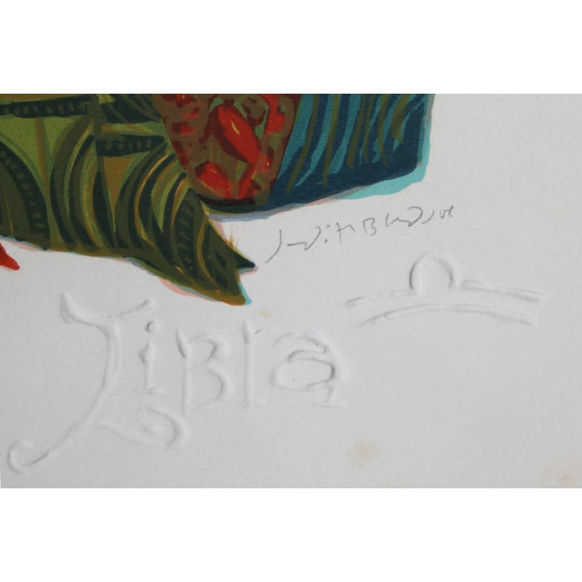 Wearing a floor-length gown of green swirling fabric, the embodiment of the astrological sign Libra holds her scale as she...