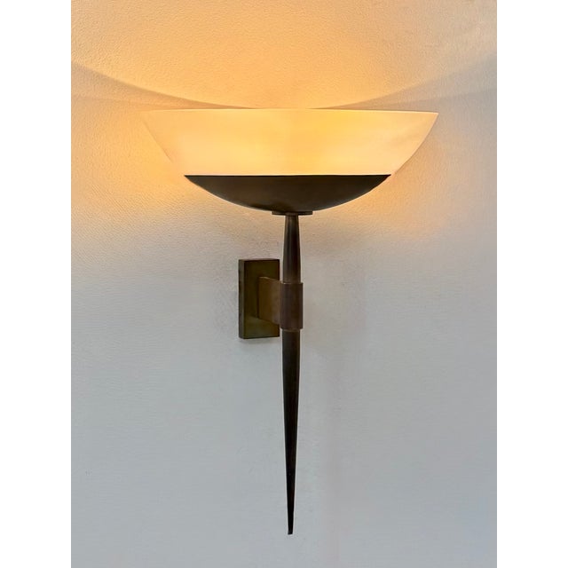 Large wall light produced in France in the 1930s, featuring a patinated brass arm and a acrylic glass diffuser. Timeless,...