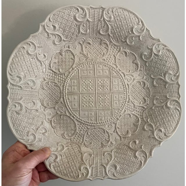 Large 18th century English George II salt glaze charger circa 1745. Decorated with relief molded rococo flourishes and...