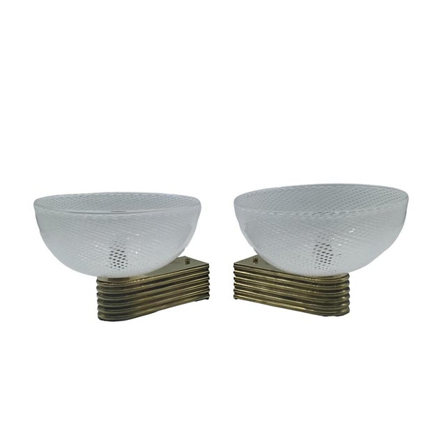 A rare pair of murano venini glass sconces; the delicate circular diffusers are entirely handcrafted using the reticello...