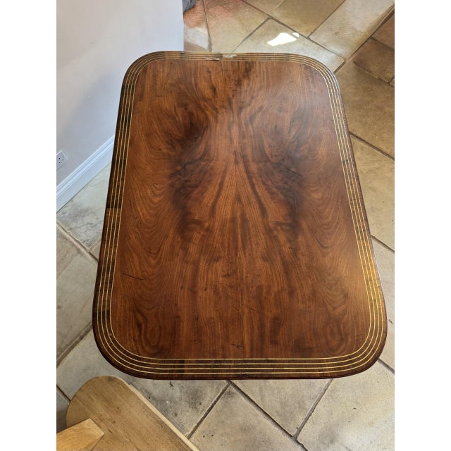 Fine quality antique figured mahogany brass inlaid dining table, having a quality figured mahogany brass inlaid top...