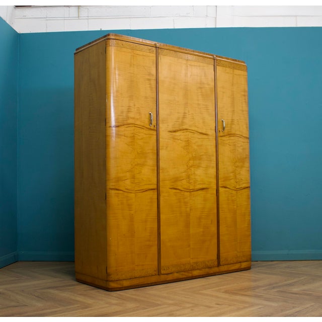 A vintage birch and walnut Art Deco triple door wardrobe, circa 1930s. Inside, beautifully fitted out with a a clothes,...