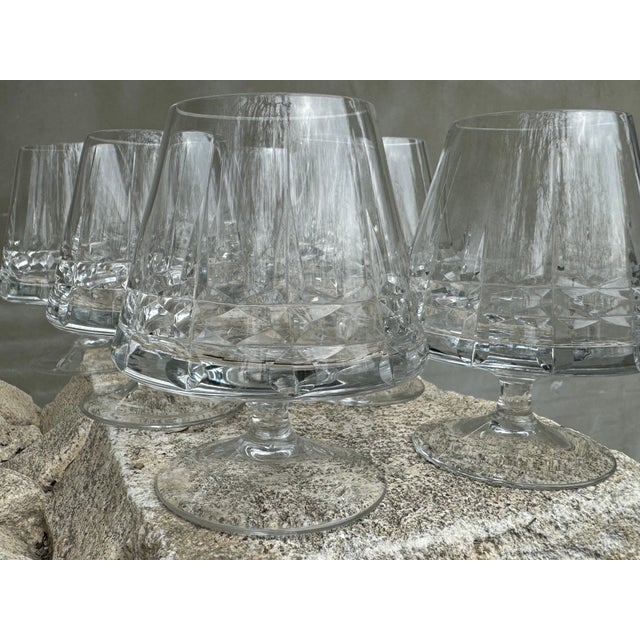 This elegant set of six vintage cut crystal cognac glasses dates from the 1970s and showcases a refined geometric cut that...