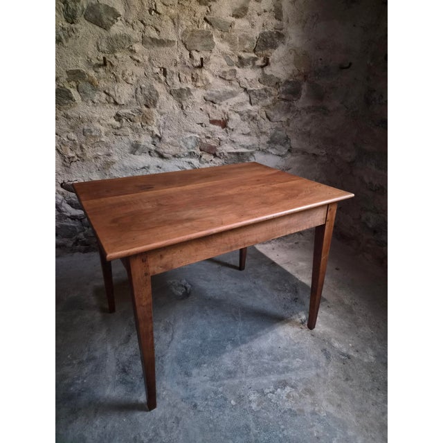 Antique French walnut table dating from the early 20th century, circa 1900–1920. The table has a rectangular top, a...