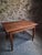 Antique French walnut table dating from the early 20th century, circa 1900–1920. The table has a rectangular top, a...