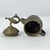 The small lidded brass bowl represents an intricate blend of artistry and commerce from centuries past, echoing the era...