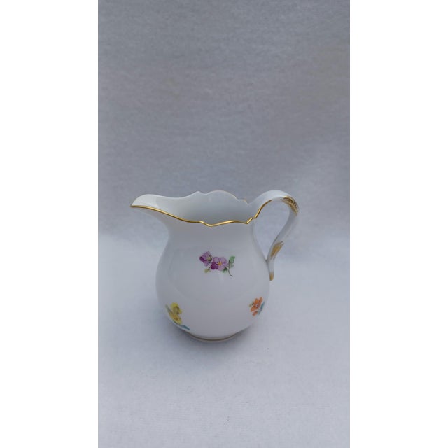 20th-Century Meissen Porcelain Miniature Creamer / Milk Jug with Hand-Painted Floral Motifs This exquisite vintage...