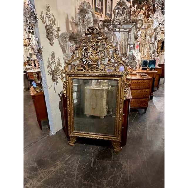 Exceptional 18th century Italian carved and giltwood mirror. Featuring a very elaborate carving at the top the mirror with...