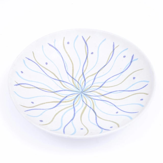 A Mid Century stoneware bowl with a swirling design of blue and green on a white field. Designed by Lee Rosen and produced...