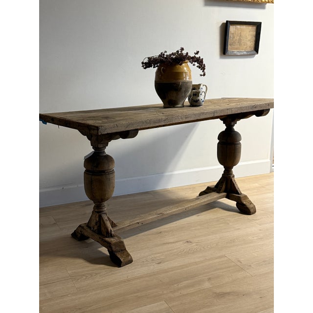 An extraordinary 17th-century French oak dining table showcasing exquisite craftsmanship and sculptural form. Its trestle...