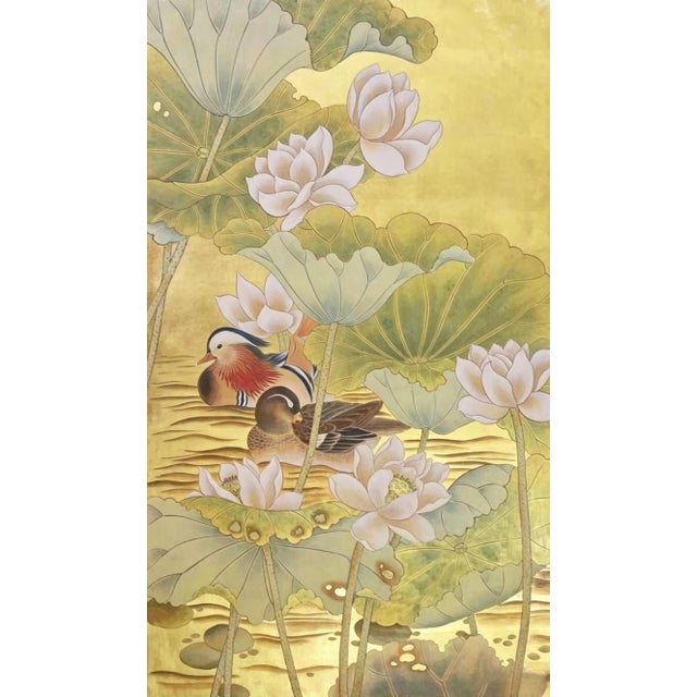 A luxurious hand painted gold leaf wallpaper featuring an elegant oriental scene of blooming lotus flowers, graceful...
