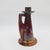 An antique candle holder or chamber stick with one handle decorated in a deep red lustre glaze accented with fiery...