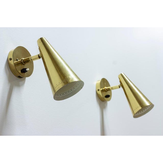 Pair of wall lamps designed and produced in finland by kt valaistus. Made during the 1950-60s. Polished solid brass with...