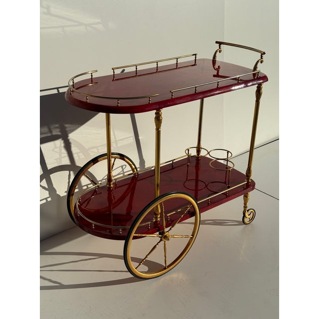 Aldo Tura Italian red parchment bar cart with brass hardware and wheels, Attributed.