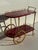 Aldo Tura Italian red parchment bar cart with brass hardware and wheels, Attributed.