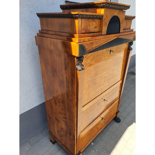 A substantial secretary desk with a hutch, featuring two drawers on the right and left, opened from the interior with...
