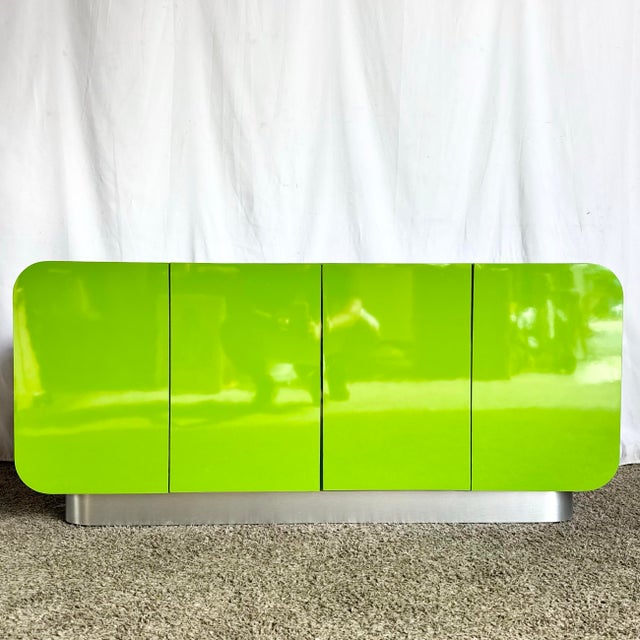 A striking postmodern credenza defined by its sculptural waterfall silhouette and saturated lime green high-gloss laminate...
