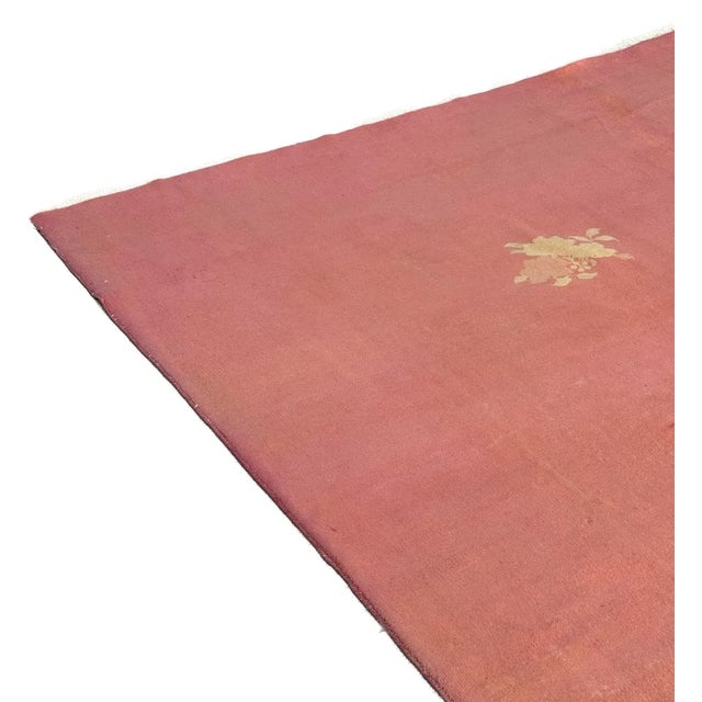 A hand-knotted masterpiece in solid salmon with elegant floral motifs at opposite corners. Meticulously crafted from...