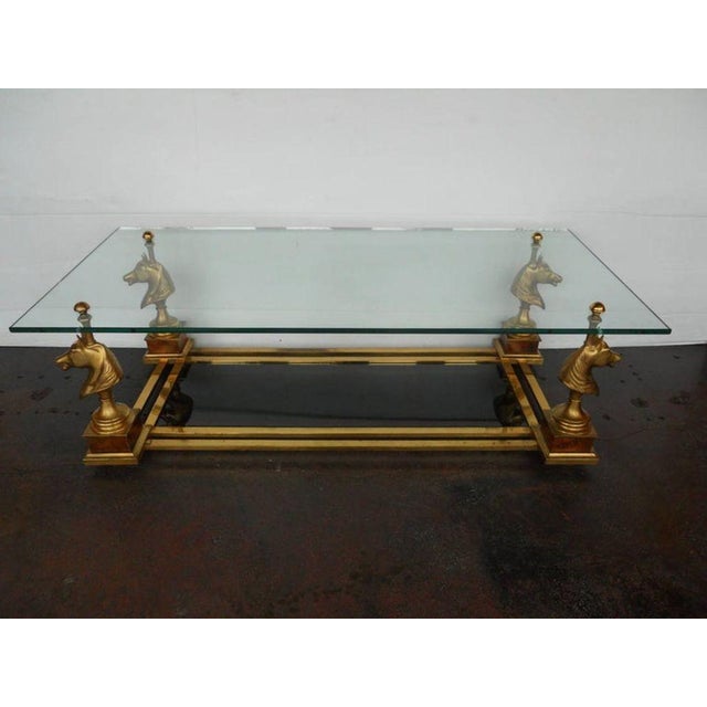 Playful and elegant Maison Charles coffee table, featuring four sculptural gilt bronze horse head figures supporting a...