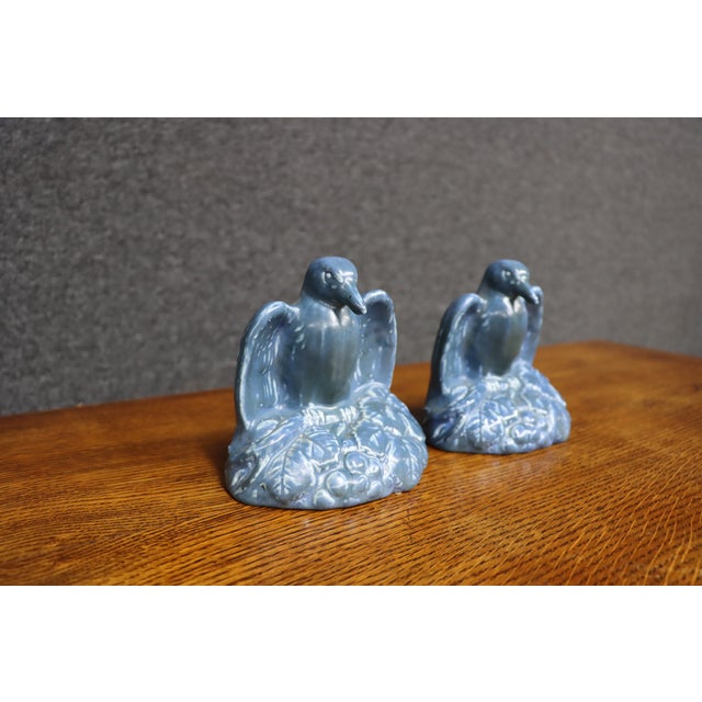 Rare pair of Rookwood Pottery figural rook bird bookends in a soft powder-blue glaze. Each stylized rook is perched in...