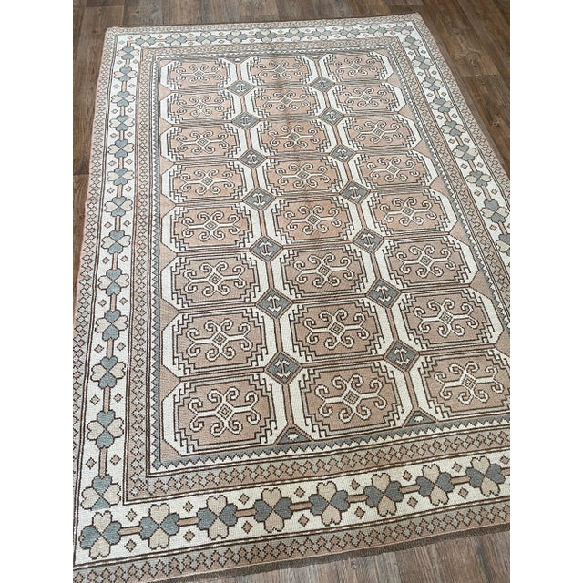 A beautiful vintage Oushak rug. This rug offers a tawny palette with blue-grey accents.