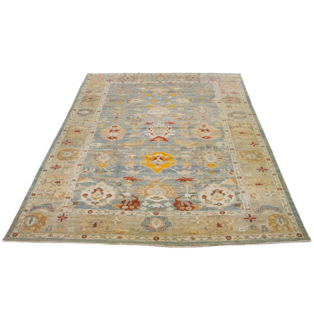 A stunning, contemporary Sultanabad rug made of oversized wool. It features a blue field adorned with multicolored accents...