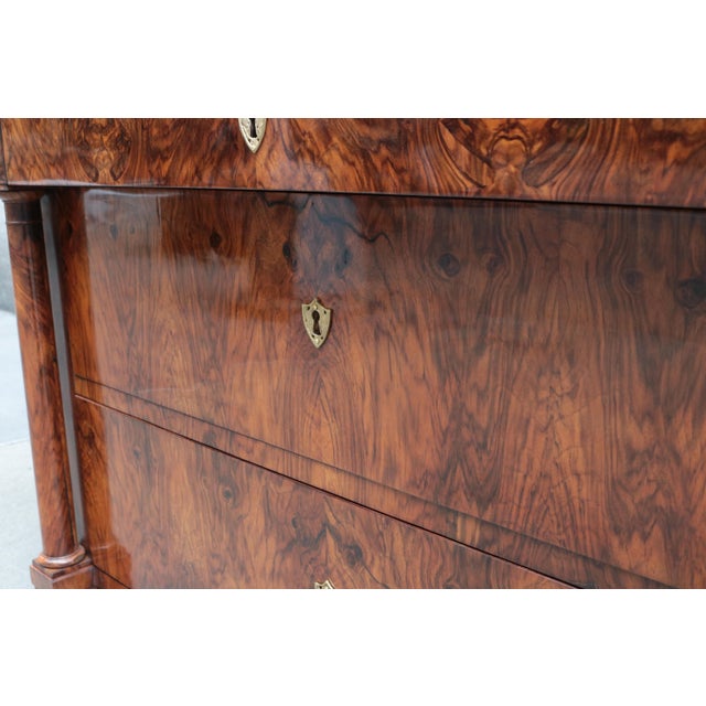 A fine single Biedermeier chest of drawers. Walnut with patinated brass escutcheons.