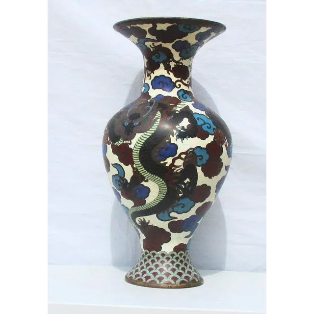 Massive enamel vase with dragon swirling among blue and brown clouds. White ground body with three black body dragons...