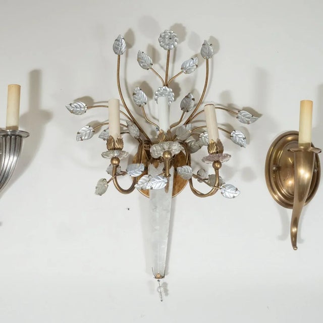 Single brass sconce with crystal and reverse silver leafed floral motif and rock crystal details in the style of Bagues.