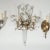 Single brass sconce with crystal and reverse silver leafed floral motif and rock crystal details in the style of Bagues.
