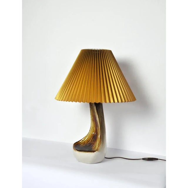 Organic shaped table lamp by Axella Stentøj in warm brown colors giving it an earthy appearance. Labeled and signed by...