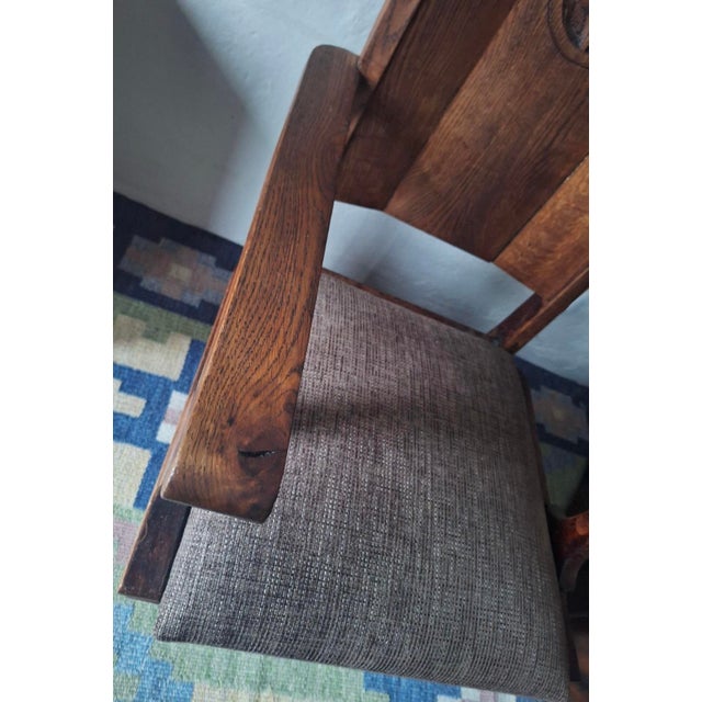Arts and crafts armchair in carved solid oak, wool-covered seat, dating from about 1910. Beautifully patinated oak.