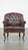 This classic and charming, correctly finished cowhide English chesterfield armchair with graceful legs. This dark cowhide...