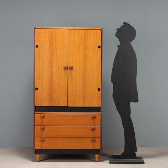 Cabinet with hinged doors in the upper part and three drawers in the lower part in teak veneer with stained wood inserts....