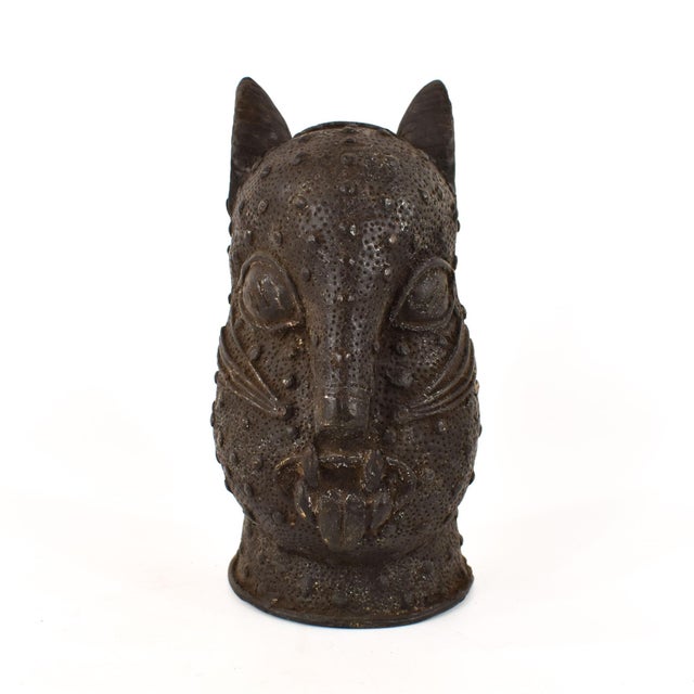 A great bronze casting of a stylized leopard head from Benin in Nigeria. Decorated with textured patterns, this cat...