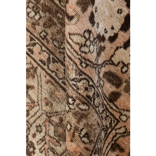 An early 20th century Tabriz Persian rug, the sand field with an architectural trellis overall of angular leafy strap...