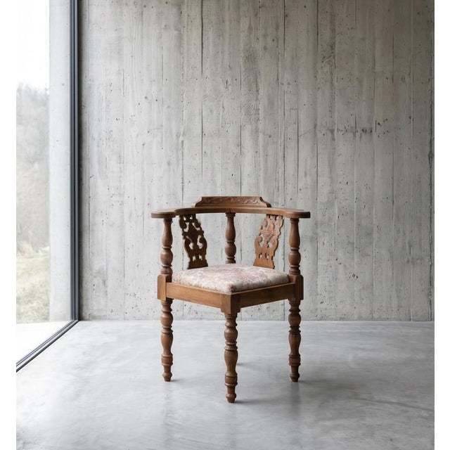 Antique oak corner chair, also known as a “Captain’s Chair,” featuring decorative carved details and a sculptural form....