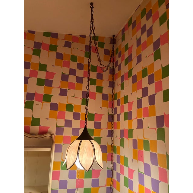 This light fixture is a vintage hanging lamp featuring a floral or tulip-shaped shade. Design: The shade is constructed...