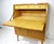 A unique secretary styled desk with locking pull down desktop with three small drawers having darker pulls and a lower...