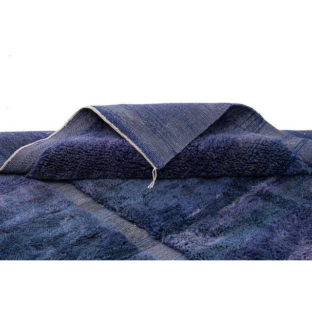 A rug that evokes the mood of a stormy twilight sky. This sophisticated hand-knotted Moroccan rug is a masterwork of...