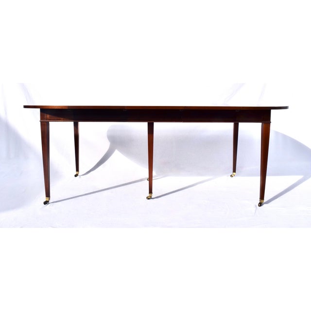An extraordinary drop Leaf dining table in the late Georgian style with Mahogany banded inlay top and tapered legs on...