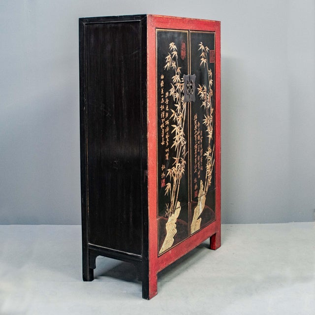 With a striking color palette and classic Chinese style, this elegant red and black lacquer cabinet features a charming...